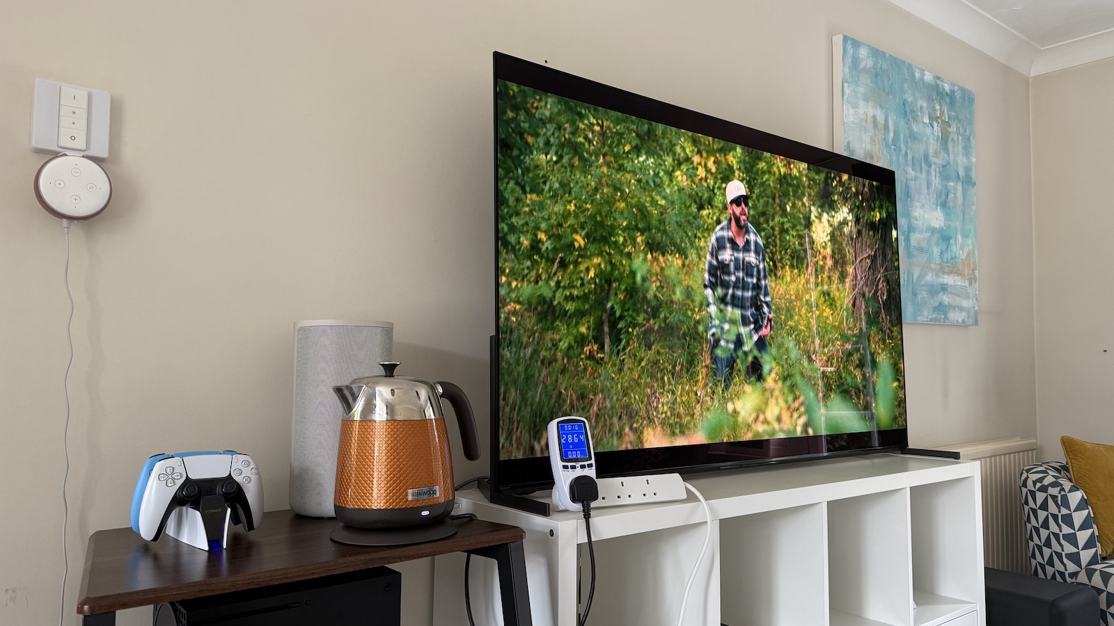 A photo of a kettle next to a large OLED TV in a living room