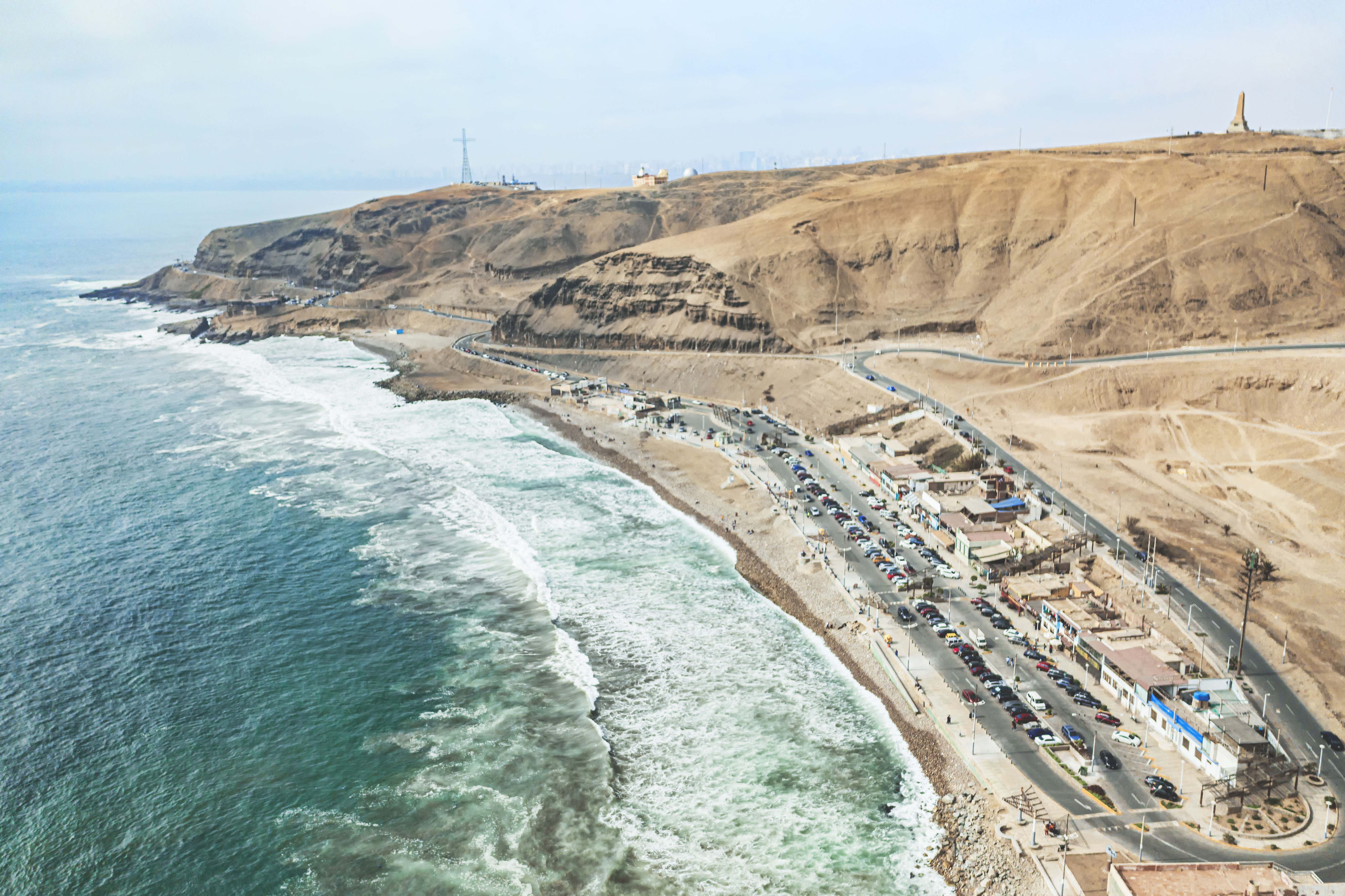 A wind-swept, sandy coast with a road running through it in a sinuous curve.