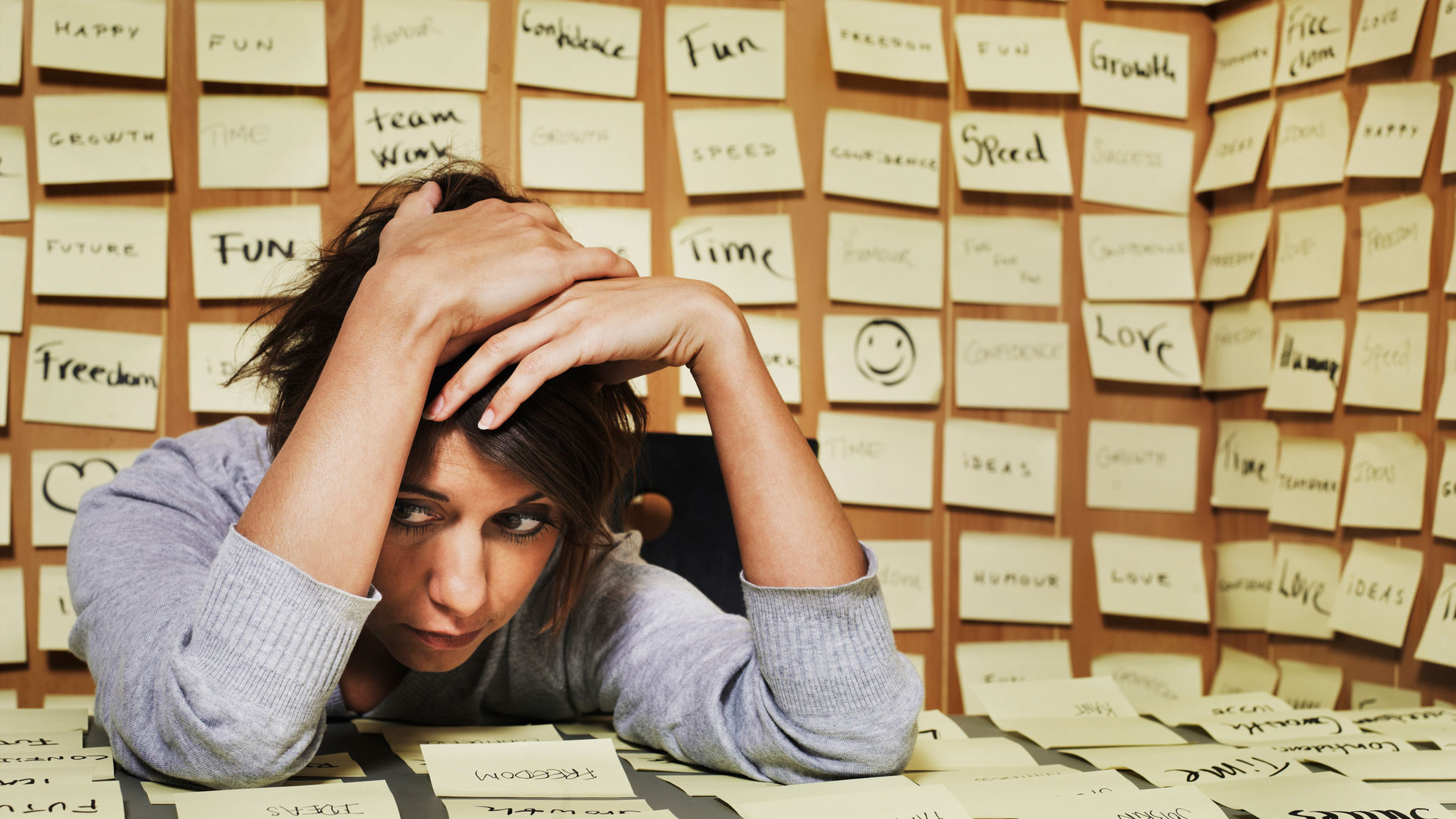 Woman sits amongst post it notes