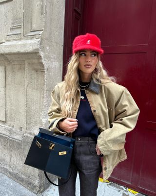 Emili Sindlev wearing a barn jacket and red hat
