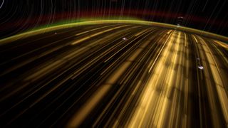 long streaks of light above earth with little white flashes visible in a timelapse photo