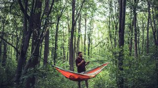 Man preparing a hammock in the woods