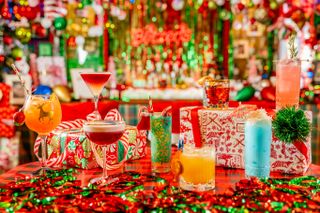 Multiple cocktails in festive glasses on the colorful bar at Blizen's Bar in San Antonio