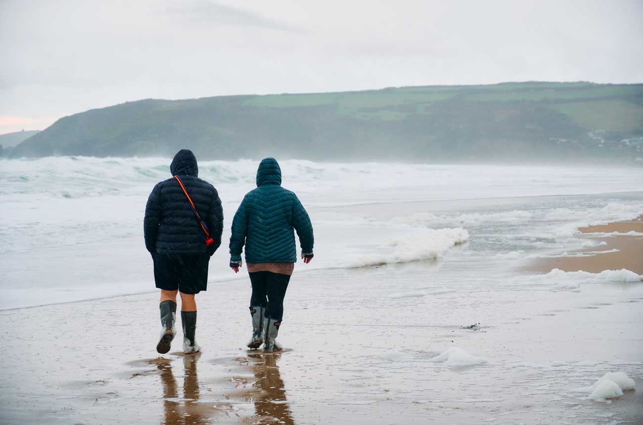 Couple walking on a beach in the rain