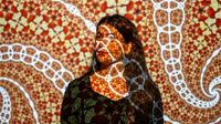Woman stands in an installation with many colours and patterns
