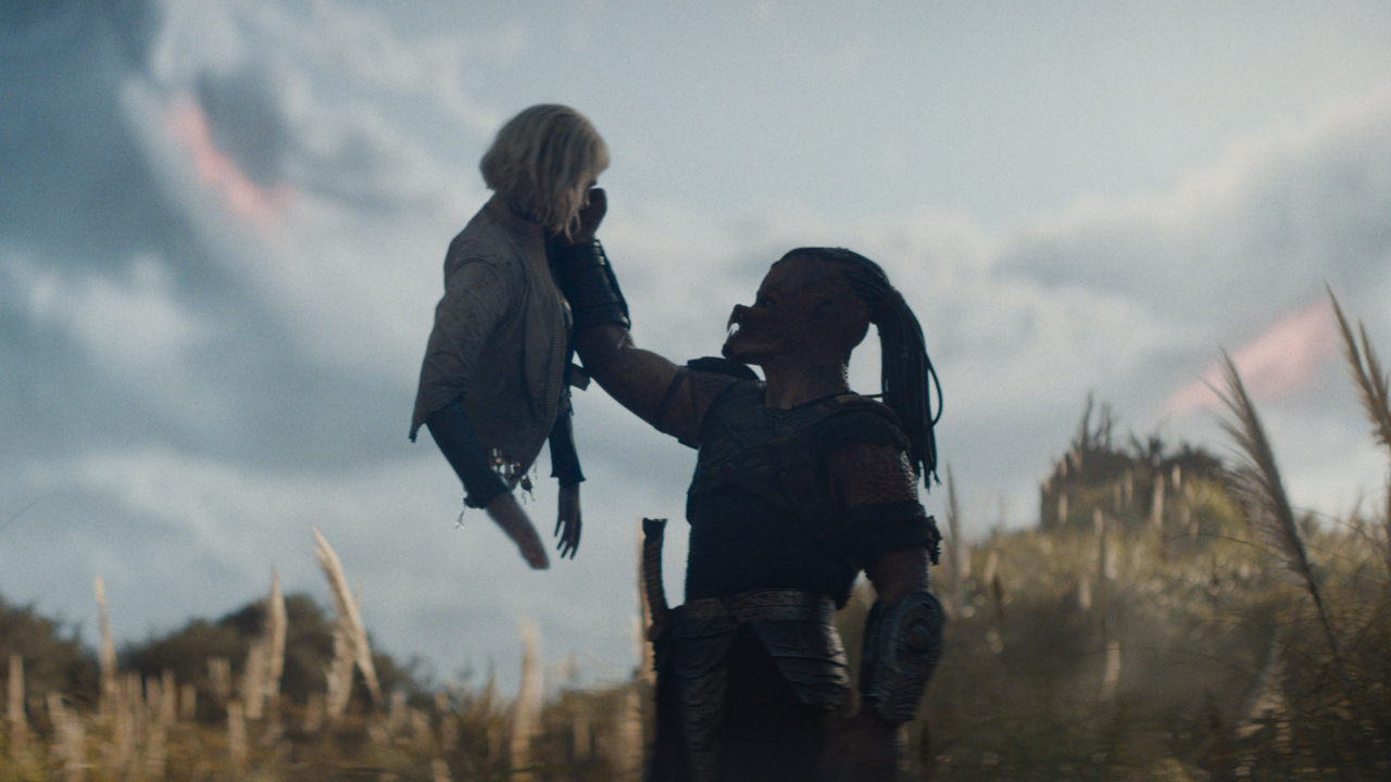 Dek holds up Thea in Predator: Badlands