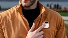 A person tapping on the Humane AI Pin worn on their jacket
