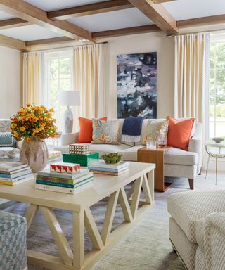 neutral living room with bright red cushions on neutral sofa