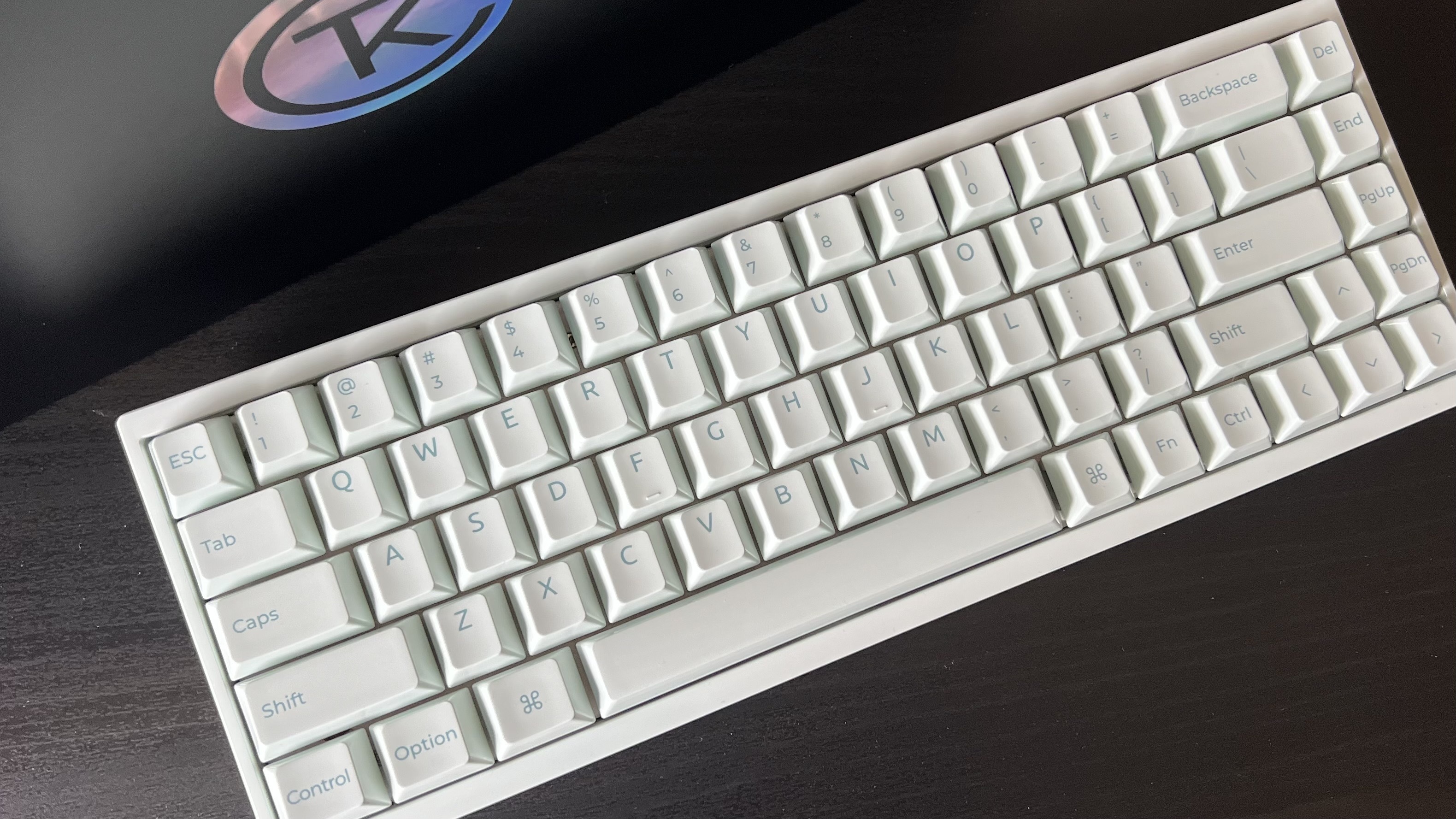 Keychron Q16 HE 8K gaming keyboard keys on a wooden desk with packaging behind