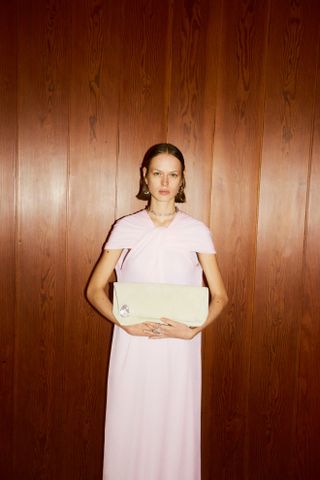 Model wearing pastel pink dress during Jil Sander resort 2025 campaign.