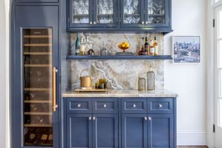 built-in home bar with blue cabinetry and shelves
