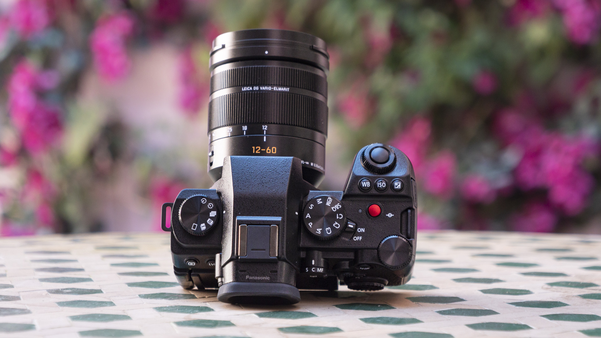 Panasonic Lumix G9 II camera on a patterned table with pink flower background