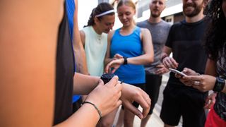 Group of runners adjusting GPS watches