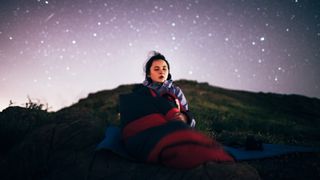 Young girl sitting under the starry sky