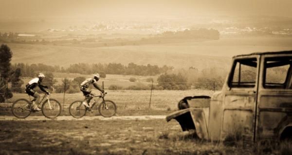 Kevin Evans and Adrien Niyonshuti pass by an old wreck
