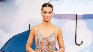 Margot Robbie in Armani naked dress on A Big Bold Beautiful Journey red carpet with umbrella background.