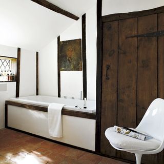 wooden bathroom with white chair bath towels