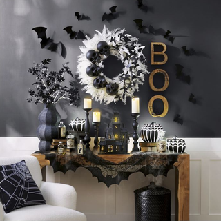 An entryway side table with bat-themed Halloween decorations