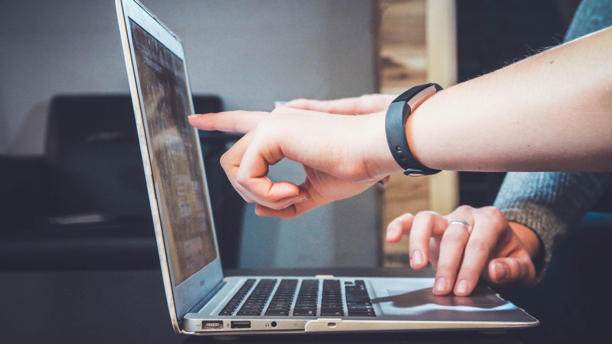 people pointing at laptop