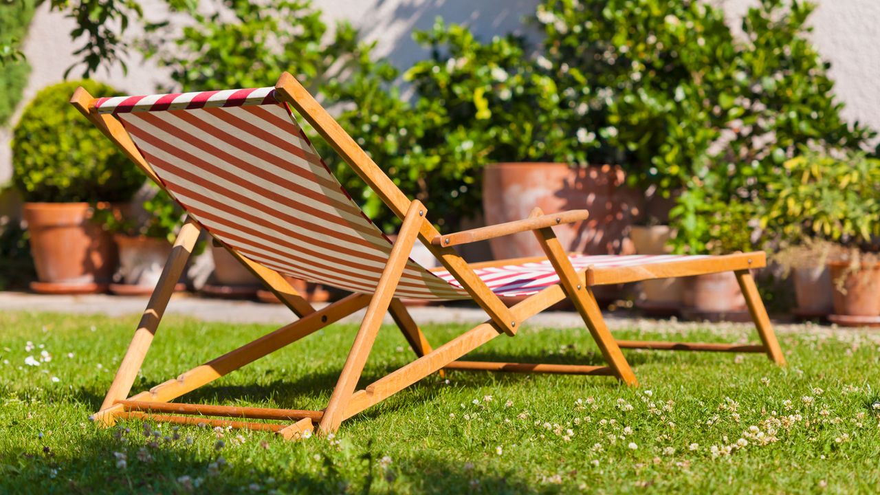 Red and white striped lawn chair on green grass