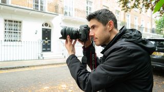 Person looking through the viewfinder of a camera, capturing the houses