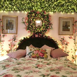 bedroom with white wall frame mirror on wall flower decoration and floral bed