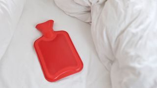 picture of red hot water bottle in bed