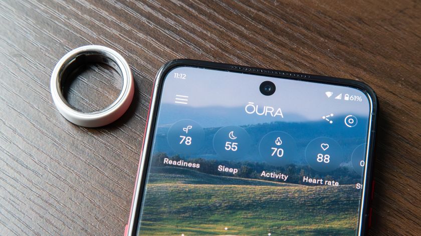 Oura Ring 4 Ceramic next to the Oura app