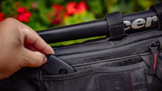 GPS tracker being placed in a frame bag
