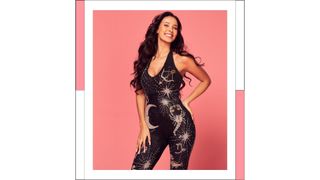Maya Jama wearing a celestial-themed jumpsuit in front of a peach/pink backdrop