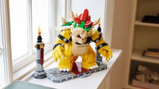 A fully constructed Lego The Mighty Bowser stands on a windowsill, looking off to one side