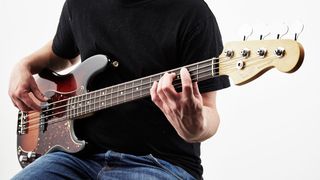 Man playing bass guitar with fingers