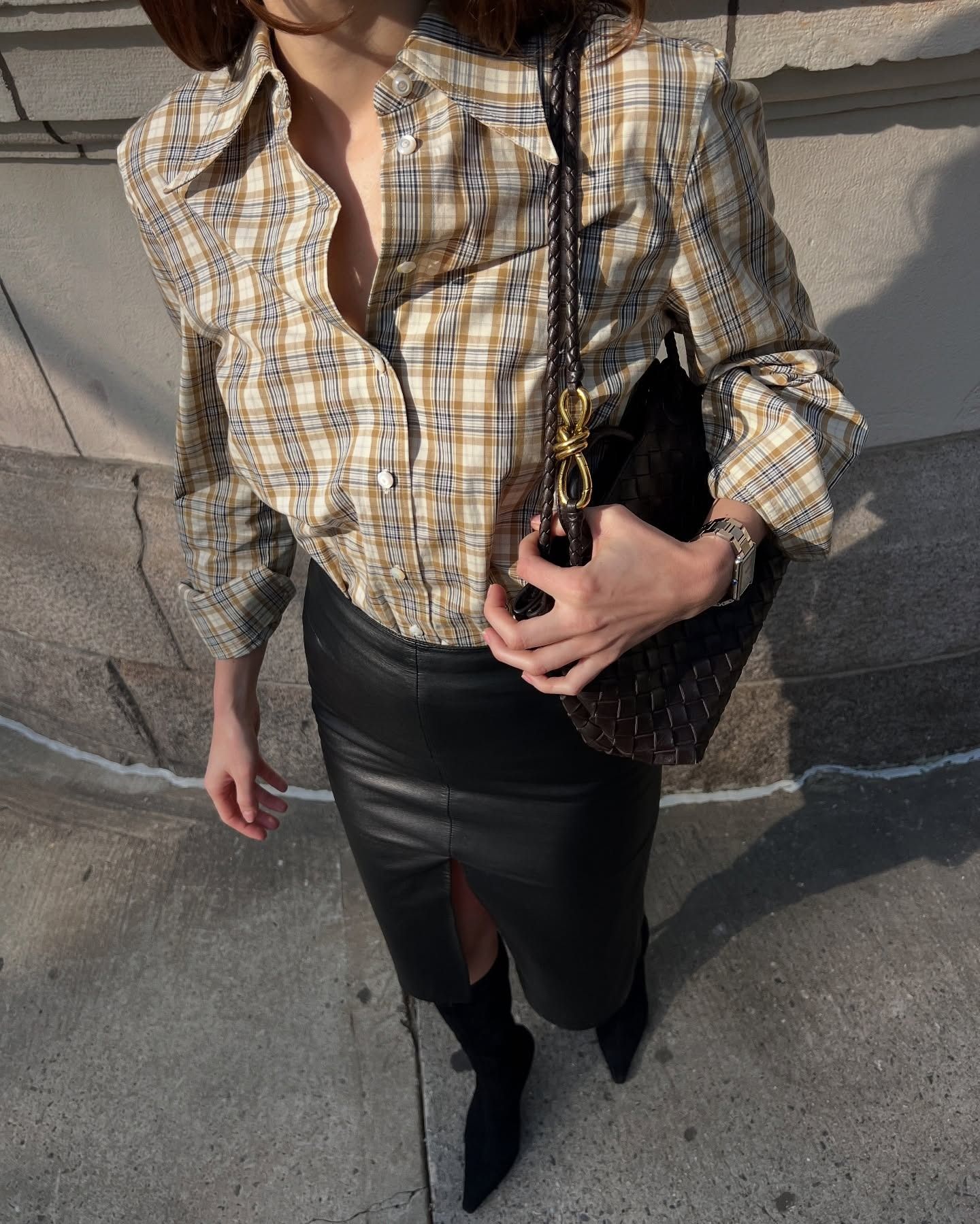 @elizagracehuber wearing a plaid shirt, leather pencil skirt, and boots.
