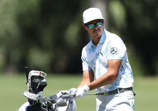 Rickie Fowler cleans a club on his golf bag towel