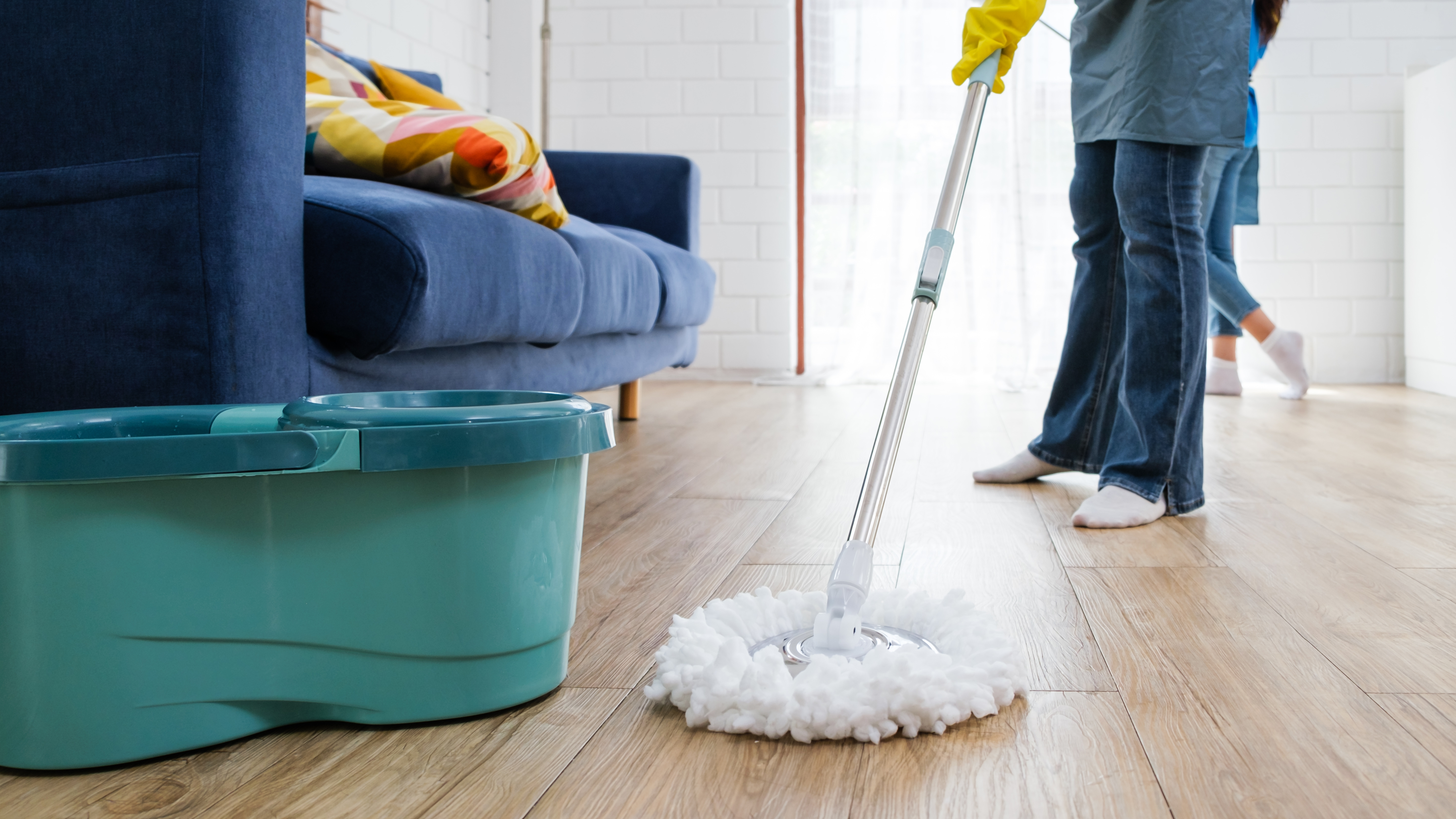 Woman mopping wooden floor with spin mop