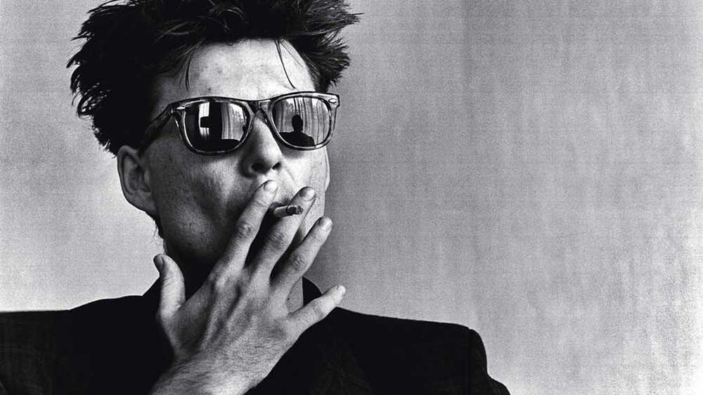 Stuart Adamson in sunglasses smoking a cigarette