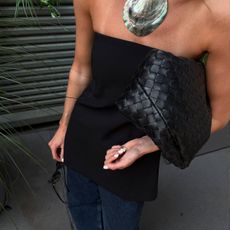 An image of @cocoschiffer wearing a black bandeau top and jeans, one of the biggest summer top trends of 2025.