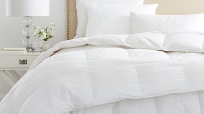 duvet vs comforter: Comforter on bed white bedding and lamp