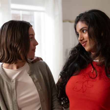 ella hunt as aj and avantika as abby looking at each other and smirking in their apartment in not suitable for work