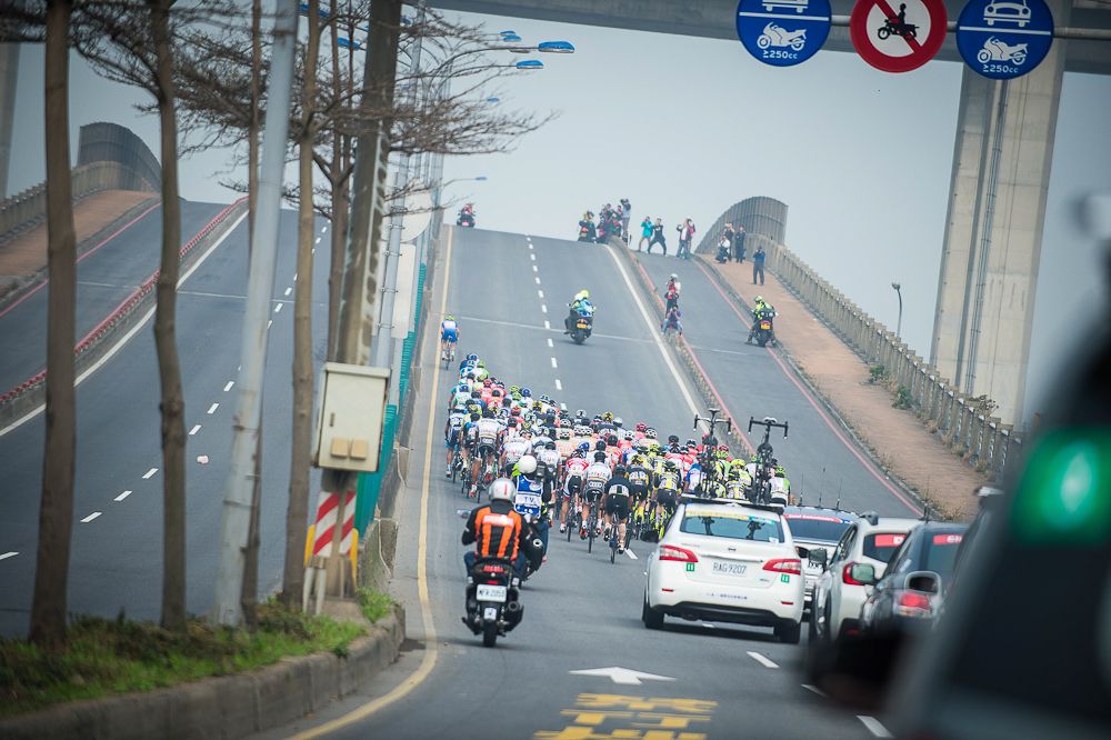 The peloton heads up and over a bridge at the Tour de Taiwan
