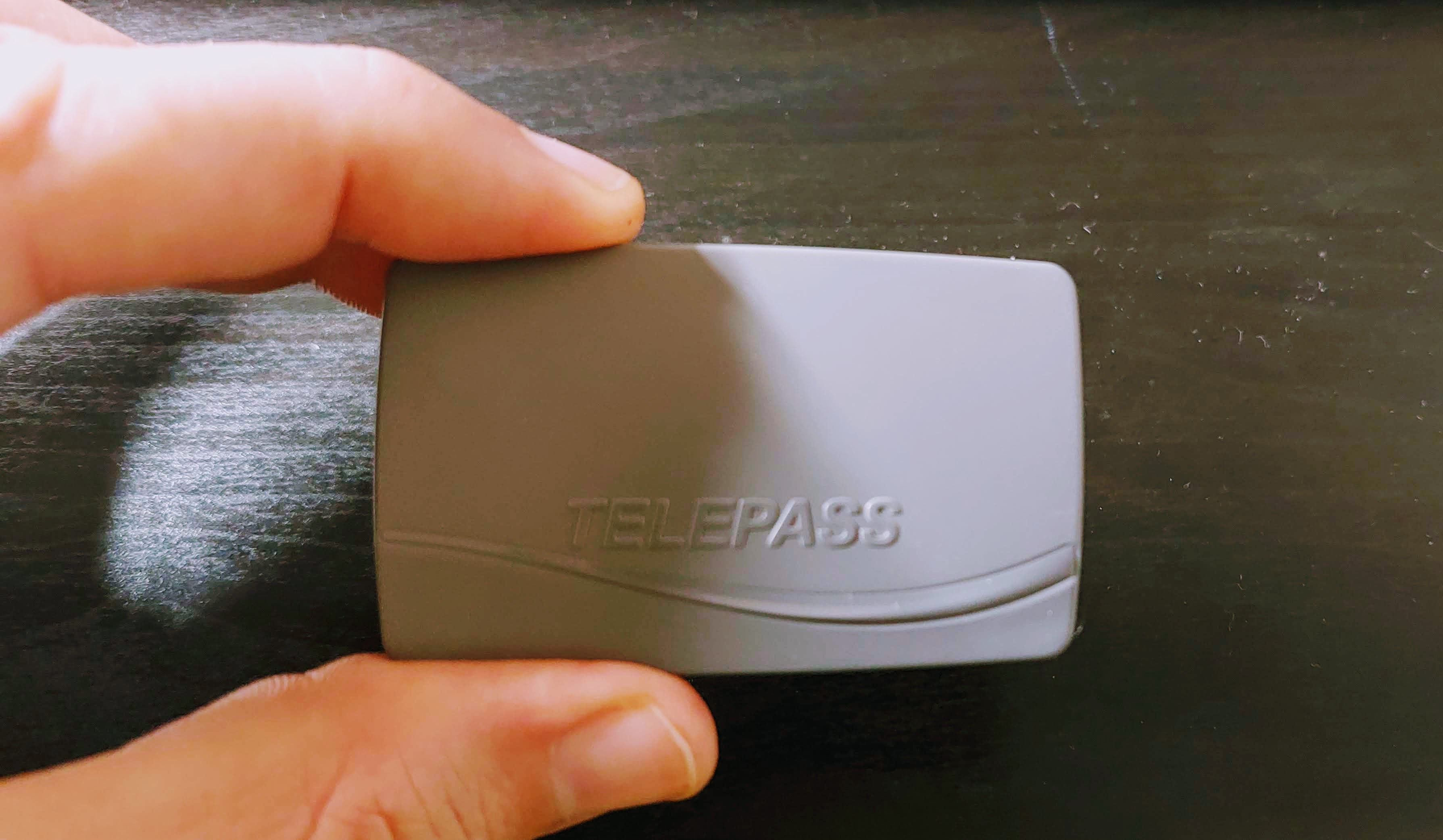 photo of hand holding telepass grey box