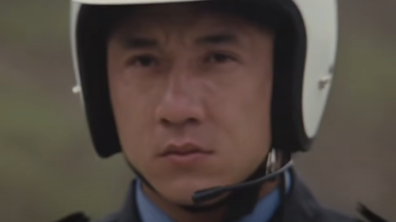 Jackie Chan sporting an intense glare in a motorcycle helmet in Police Story