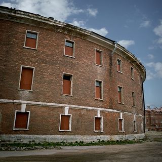 Curved brick building with boarded up windows