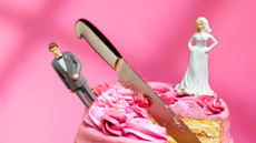 Knife cutting cake between bride and groom figurines