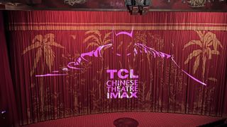 A title graphic for The Batman at the TCL Chinese Theater IMAX is overlaid on a curtain in the theater