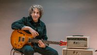 David Grissom holding his DGT signature guitar next to an amp