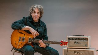 David Grissom holding his DGT signature guitar next to an amp