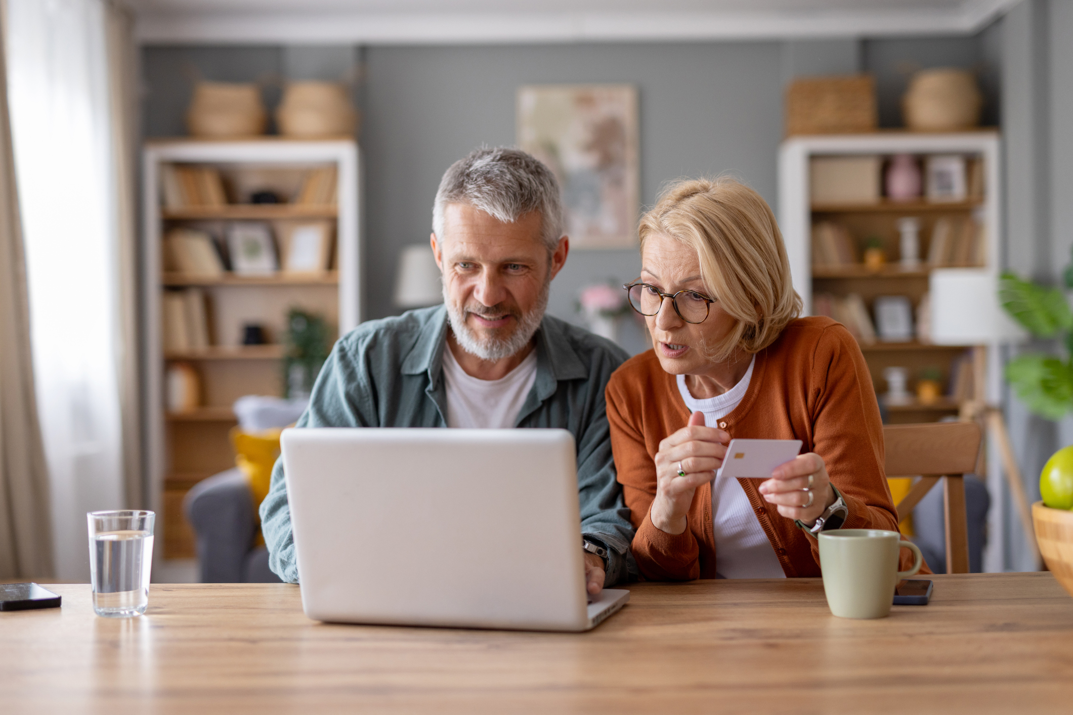 A warm and engaged older couple discovering online shopping and sharing their joy and curiosity about purchasing products at home.