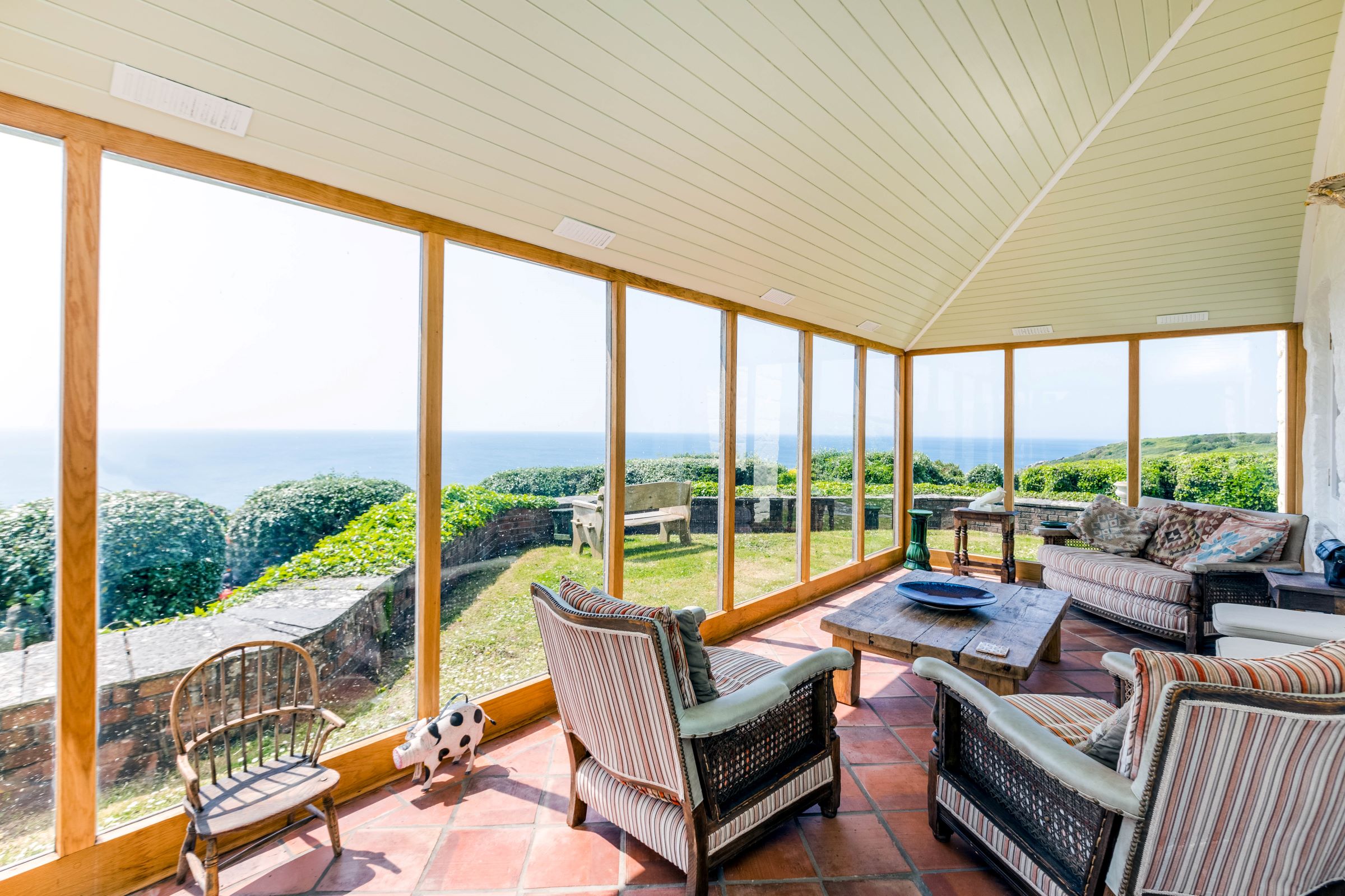 The timber conservatory faces onto the sea with 180 degree views