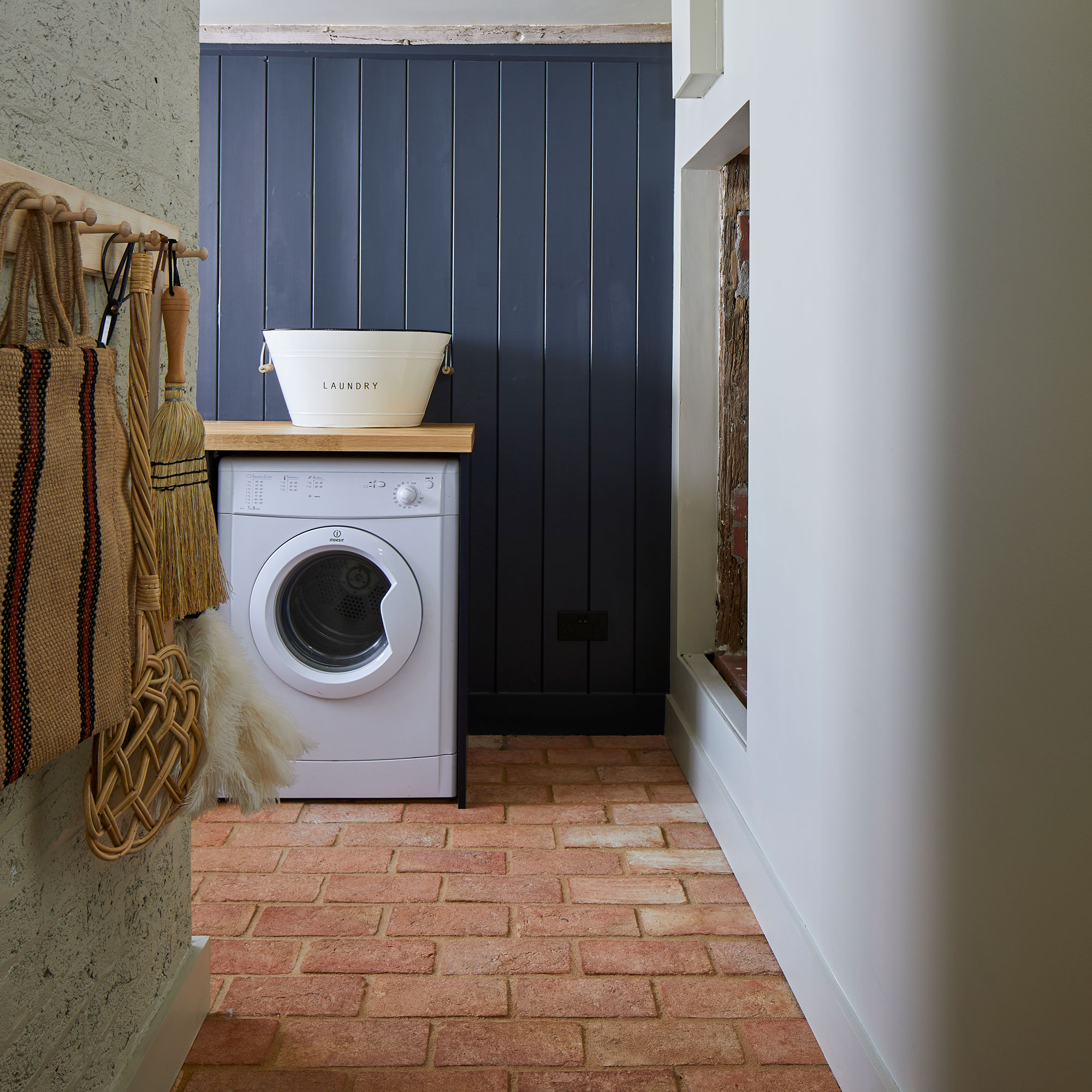 utility room with brick floor and navy wall panelling
